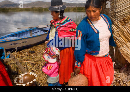 Uros island, il lago Titicaca, Perù, Sud America. Due donne abbigliate con vestiti tipici costumi regionali su una delle isole uros. Foto Stock