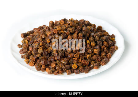 Granuli di propoli all'interno della piastra sullo sfondo, prodotto delle api Foto Stock