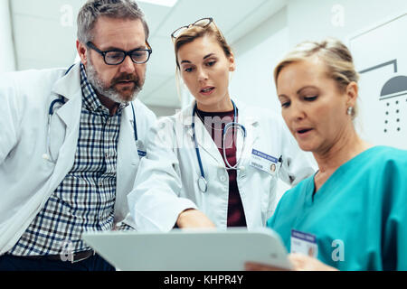 Il personale medico a discutere su referti medici. I professionisti del settore sanitario avente la discussione nel corridoio dell'ospedale. Foto Stock