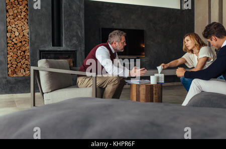 Giovane vedendo una psicoterapeuta per risolvere i loro problemi di relazione. Triste donna prendendo un tessuto di carta durante la sessione di terapia. Foto Stock