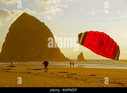 Kite flier a Cannon Beach con haystack rock stack del mare sullo sfondo. Foto Stock