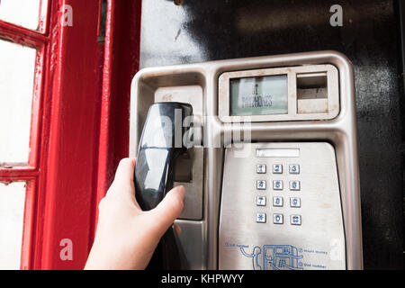 Utilizzo di un telefono cellulare BT nella scatola telefonica rossa Foto Stock