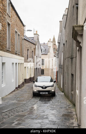 Auto che attraversa le strette strade acciottolate del centro storico di Stromness, Orkney Mainland, Scozia, Regno Unito Foto Stock