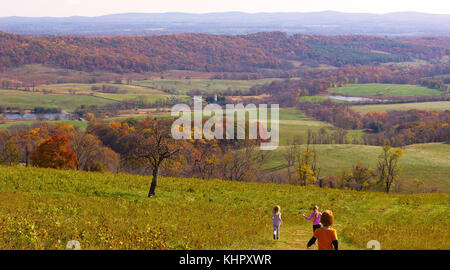 DELAPLANE, VIRGINIA, Stati Uniti – 6 NOVEMBRE 2016: Paesaggio di campagna autunnale con bambini che corrono dalla cima della collina. Lo Sky Meadow State Park offre una vasta gamma di attività ricreative Foto Stock