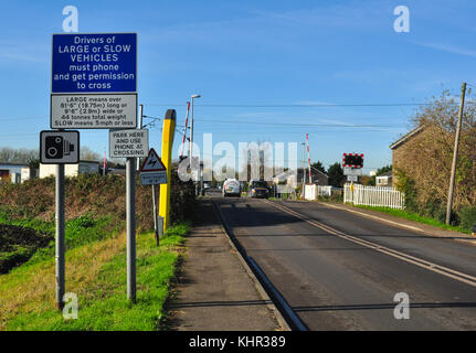 Uno dei passaggi a livello (King's Lynn linea ferroviaria) sulla strada che attraversa la frazione di regina Adelaide, vicino a Ely, Cambridgeshire, England, Regno Unito Foto Stock