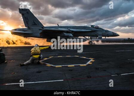 Un U.S. NAVY F/A-18E Super Hornet jet da combattimento aereo decolla dal ponte di volo della marina degli Stati Uniti nimitz-class portaerei USS Ronald Reagan al tramonto novembre 11, 2017 nell'oceano pacifico. (Foto di janweb b. lagazo via planetpix) Foto Stock