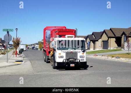 Un rosso immondizia camion che attraversano un incrocio. Foto Stock