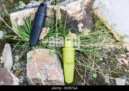 Due coltelli svedese in guaina di plastica. Una foto sullo sfondo della natura. Foto Stock