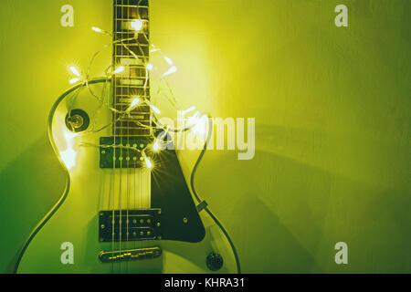 La chitarra su sfondo chiaro. Anno nuovo dono sotto forma di costosi chitarre elettriche. regalo per il musicista a Natale. uno strumento musicale nel Foto Stock