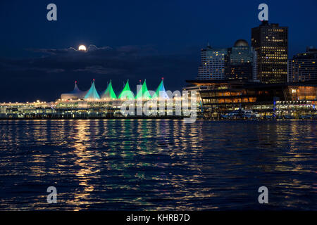 Vancouver, British Columbia, Canada - 9 giugno 2017 - Fragola moon rising dietro le nuvole sopra il Canada Place, il centro congressi e il centro cittadino di buildi Foto Stock