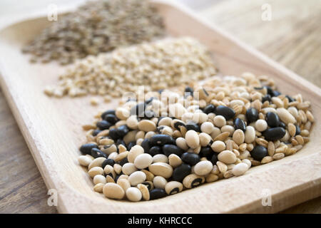Non cotti zuppa di cereali e legumi in un piatto di legno Foto Stock