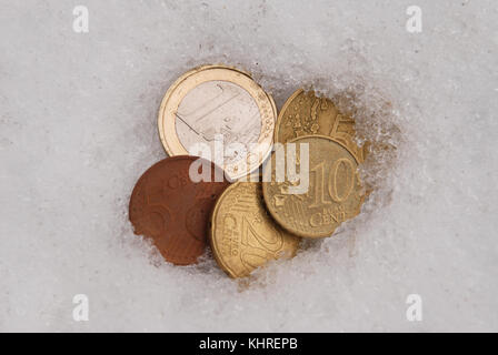 La perdita di monete su una neve. Monete in euro Foto Stock