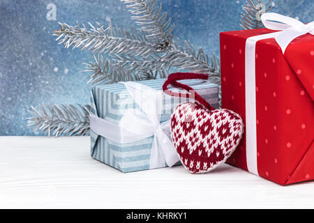 Fatte a mano le decorazioni di Natale, presenti caselle e abete bianco ramo di albero su sfondo blu Foto Stock