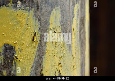 La texture di incrinate e peeling vernice gialla sul polo di calcestruzzo Foto Stock