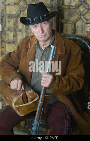 Bandito maschio anziano con fucile nel selvaggio West Foto Stock