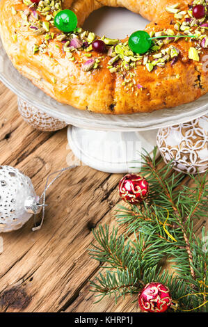 Torta di Natale decorato con cocktail di ciliegia e dadi con una candela Foto Stock