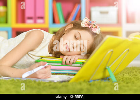 Poco carino ragazza di addormentarsi sui libri Foto Stock