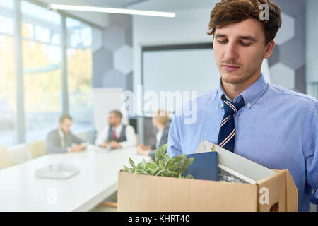 Ritratto di giovane triste in scatola di contenimento di oggetti personali licenziato dal lavoro in azienda, spazio di copia Foto Stock