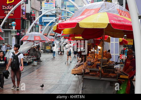 Il coreano street food stallo a Busan Food Street. La donna non identificato la preparazione tradizionale Coreana di cibo di strada. Foto Stock