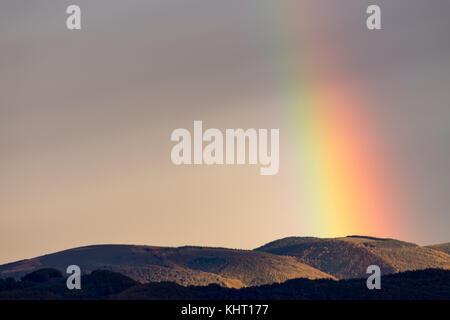 Bellissimo e surreale vista di parte di un arcobaleno su alcune colline Foto Stock