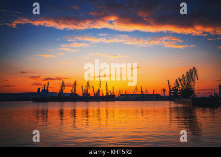 Colorato tramonto sul porto di mare e le gru industriali, Varna, Bulgaria Foto Stock