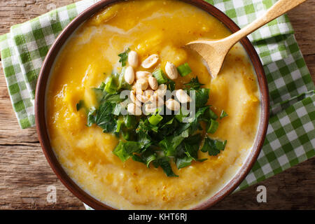 Thai curry di zucca minestra con noccioline e coriandolo vicino sul tavolo. parte superiore orizzontale vista da sopra Foto Stock