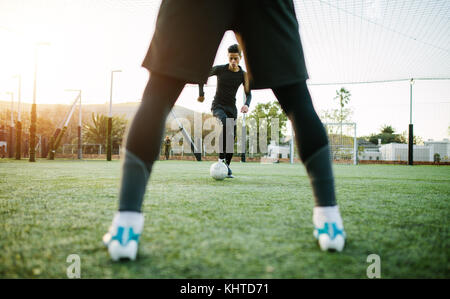 I giocatori di calcio durante la pratica del team in campo. Giovani calciatori giocano su sport campo d'erba. Foto Stock