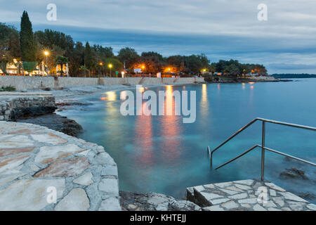 Sumer mediterranea resort con mare adriatico spiaggia rocciosa a sera. Istria, Croazia Foto Stock