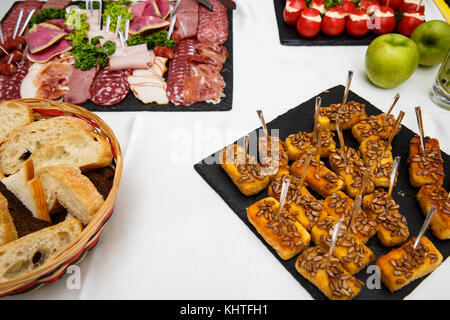Formaggio bastoni. Vassoio per alimenti con deliziosi salami, pezzi di fette di prosciutto, salsiccia, insalata. Pane. Pomodori ripieni di formaggio e aglio - piatto a base di carne wi Foto Stock