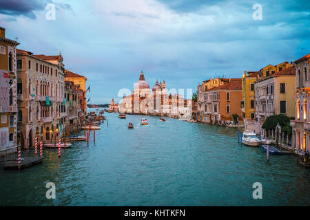 Vista dal Ponte dell'Accademia su barche e le gondole del Canal Grande di Venezia in un giorno nuvoloso durante il tramonto incandescente Foto Stock