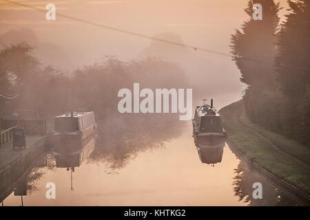 Autunno nebbia di mattina nebbia Cheshire, Tiverton Tarporley. Narrowboats ormeggiato a lato dell'ombreggiato Oak pub sulla Shropshire Union Canal Foto Stock