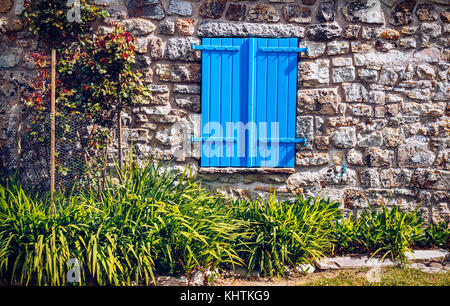 Chiusa la finestra blu tende a casa di pietra Foto Stock