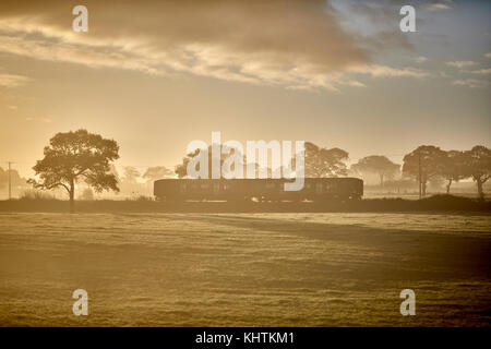 Autunno nebbia di mattina nebbia campagna di Cheshire , Tiverton, Tarporley. Un arriva il treno diretto a Chester Foto Stock