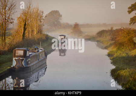 Autunno nebbia di mattina nebbia Cheshire, Tiverton Tarporley. Narrowboats ormeggiato a lato dell'ombreggiato Oak pub sulla Shropshire Union Canal Foto Stock