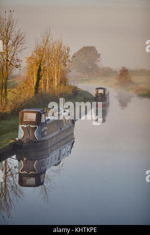 Autunno nebbia di mattina nebbia Cheshire, Tiverton Tarporley. Narrowboats ormeggiato a lato dell'ombreggiato Oak pub sulla Shropshire Union Canal Foto Stock