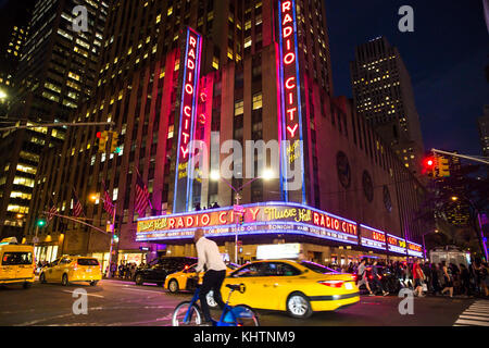 New York City - 28 settembre 2017: vista della trafficata strada notte fuori scena radio city music hall sulla Sesta Avenue nel centro di Manhattan. Foto Stock