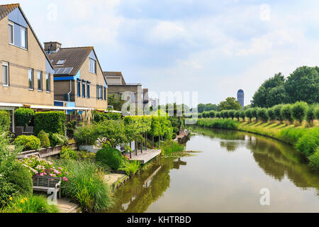 Case residenziali sulla riva con un water tower sullo sfondo si trova nella città olandese zoetermeer, distretto rokkeveen. Foto Stock