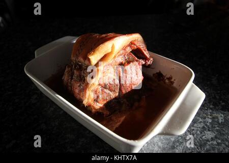 Il 19 novembre 2017. Gloucestershire, Inghilterra. Home Cucinato arrosto di maiale giunto di carne nel piatto di tostatura. Foto di Hector Foto Stock