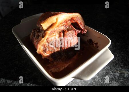 Il 19 novembre 2017. Gloucestershire, Inghilterra. Home Cucinato arrosto di maiale giunto di carne nel piatto di tostatura. Foto di Hector Foto Stock