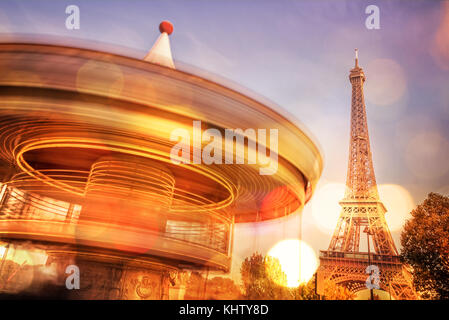 Giostra vintage e la torre Eiffel di notte, offuscata bokeh luci, parigi francia Foto Stock