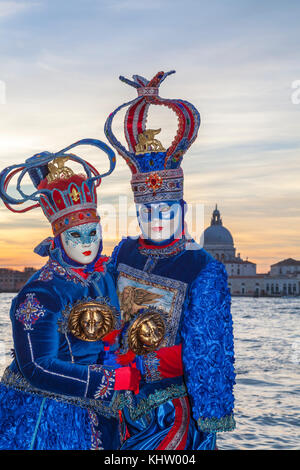 Venezia, Carnevale 2017, Veneto, Italia, giovane al tramonto presso la laguna. L uomo e la donna in costume tradizionale e maschera Foto Stock