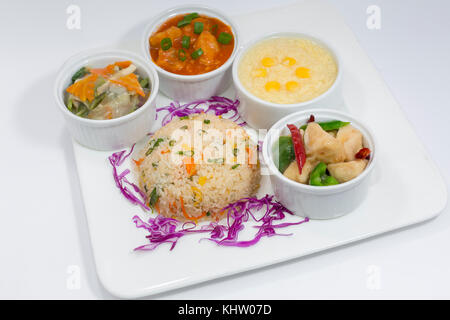 Pollo sichuan, dolce & acida pesce, verdure miste, riso fritto e la zuppa di mais piatto. Foto Stock