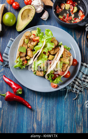 Autentica tacos messicano con pollo e salsa con avocado, pomodori e peperoncino. cucina messicana. Foto Stock