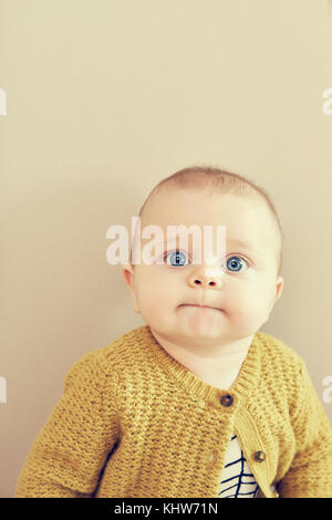 Ritratto di blue eyed baby boy tirando una faccia Foto Stock