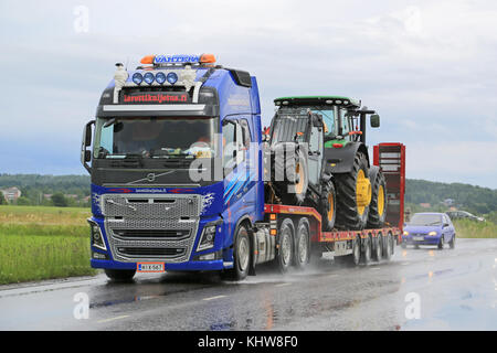 Salo, Finlandia - 10 luglio 2015: Volvo fh16 cale john deere macchine sul rimorchio con collo d'oca. Volvo Trucks certificare tutti i motori per il diesel hvo. Foto Stock