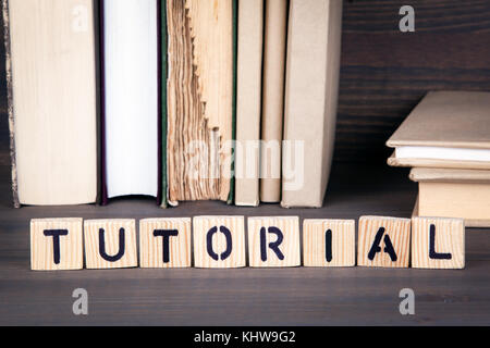 Tutorial, lettere di legno su un tavolo di legno. Istruzione, successo e lo sfondo di comunicazione Foto Stock