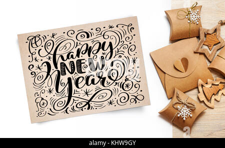 Lettering felice anno nuovo biglietto di auguri - testo in vintage carta kraft su uno sfondo bianco. flat laico, top view photo mockup Foto Stock