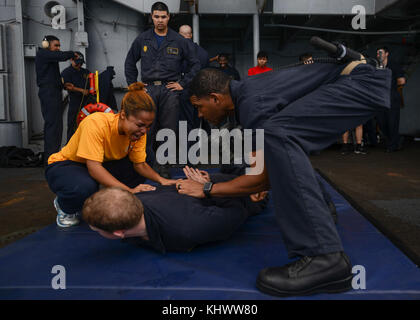 PACIFIC OCEAN (Nov. 16, 2017) i marinai partecipano ad un corso di qualificazione di oleoresina capsicum (OC) a bordo della portaerei USS Nimitz (CVN 68). Il Nimitz Carrier Strike Group è in fase di implementazione nell'area operativa della settima flotta statunitense a sostegno delle operazioni di sicurezza marittima e degli sforzi di cooperazione per la sicurezza del teatro. La flotta del Pacifico degli Stati Uniti ha pattugliato regolarmente l'Indo-Pacifico per più di 70 anni promuovendo la sicurezza, la stabilità e la prosperità regionali. (STATI UNITI Fotografia Navy di Mass Communication Specialist 2° Classe Holly L. Herline/rilasciata) Foto Stock