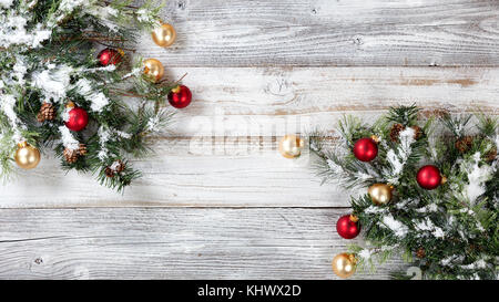Natale ruvida abete decorato con rosso e ornamenti d'oro su weathered bianco sullo sfondo di legno Foto Stock