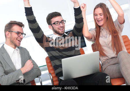 Tre dipendenti eccitati ricevendo buone notizie insieme sulla linea Foto Stock